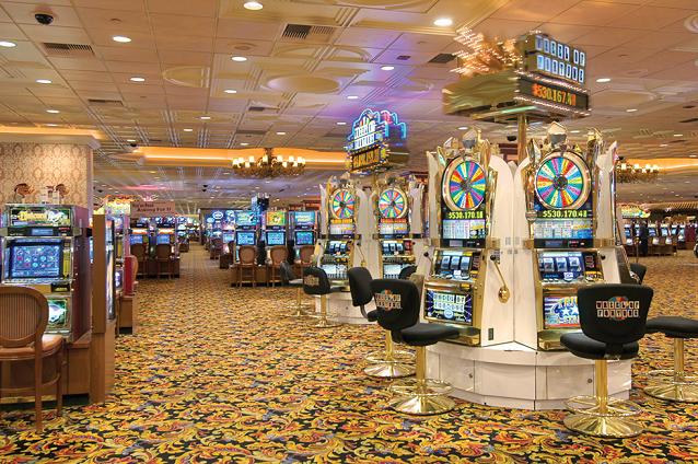 Сверкающие залы Gold Coast Hotel and Casino с бесчисленными однорукими бандитами, аппаратами и другими азартными играми и ставками.