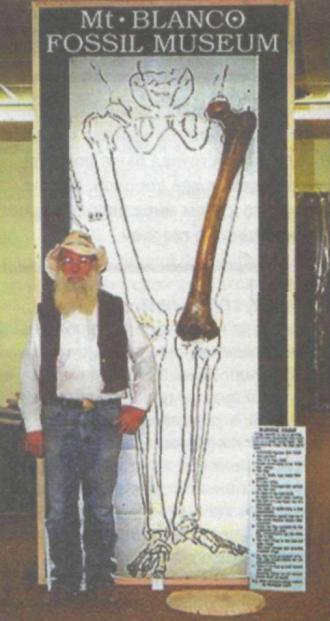 Человек рядом со скелетом великана